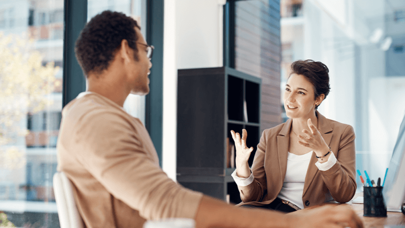 Two professionals having a positive conversation together in an office space