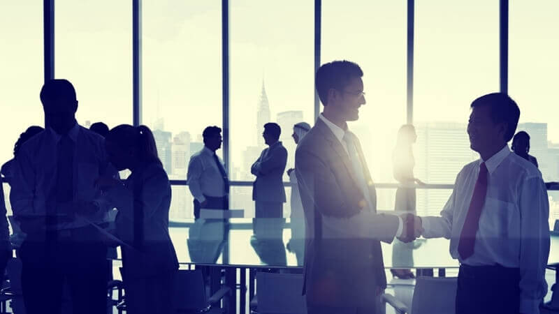 People conversing in an open office with a skyline backdrop