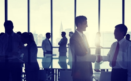 People conversing in an open office with a skyline backdrop